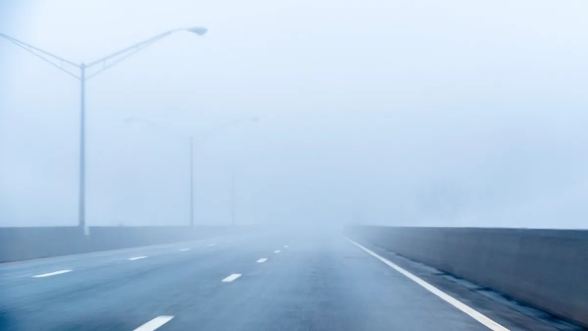 A city highway with streetlights fading into thick haze